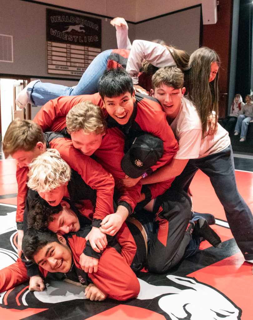 Kids pile-on a wrestling mat