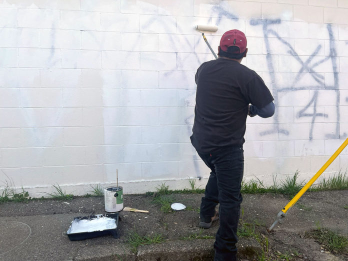 Painting over graffiti on Alley 8